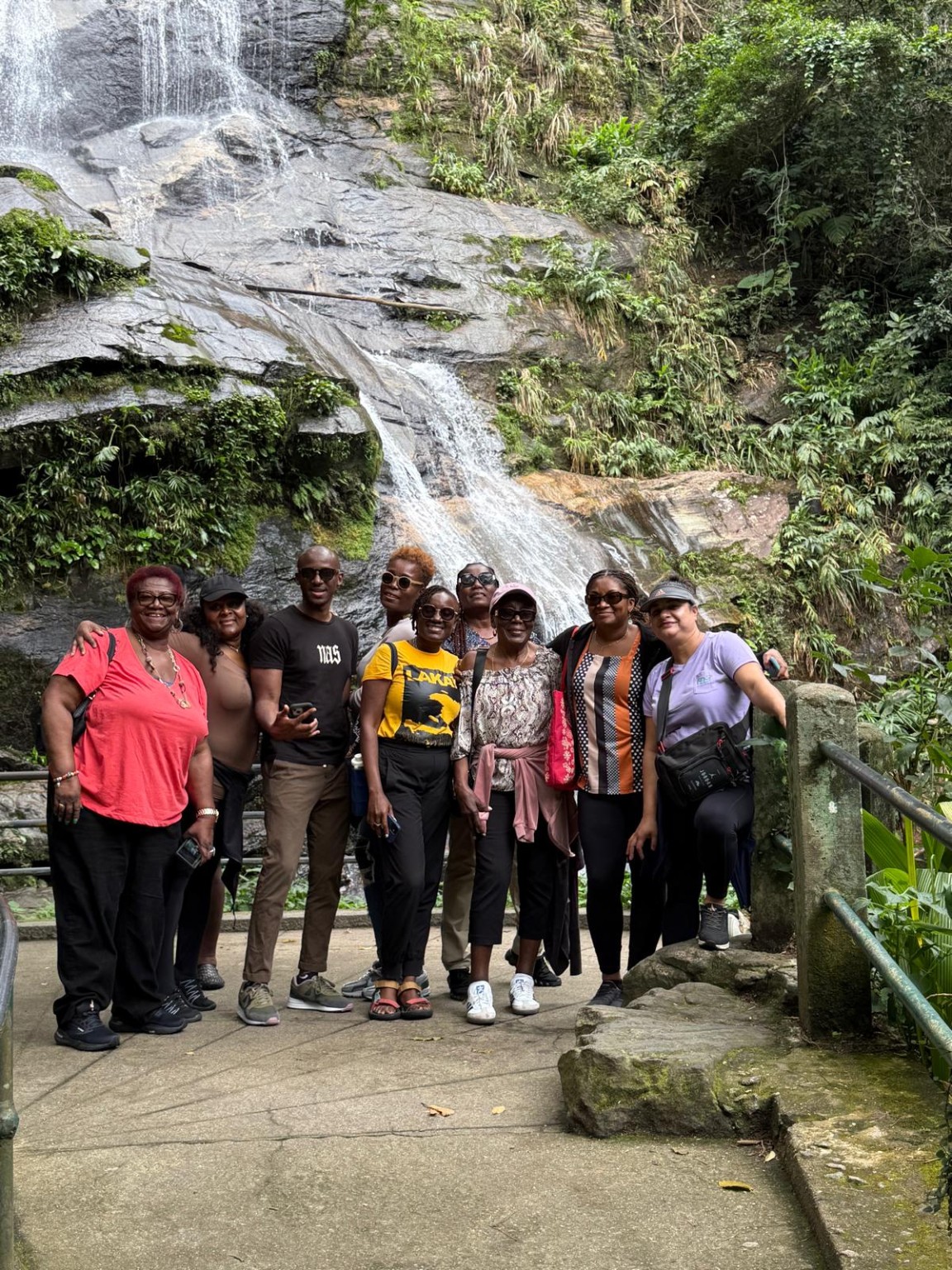 Travel group together in front of a waterfall in Brazil